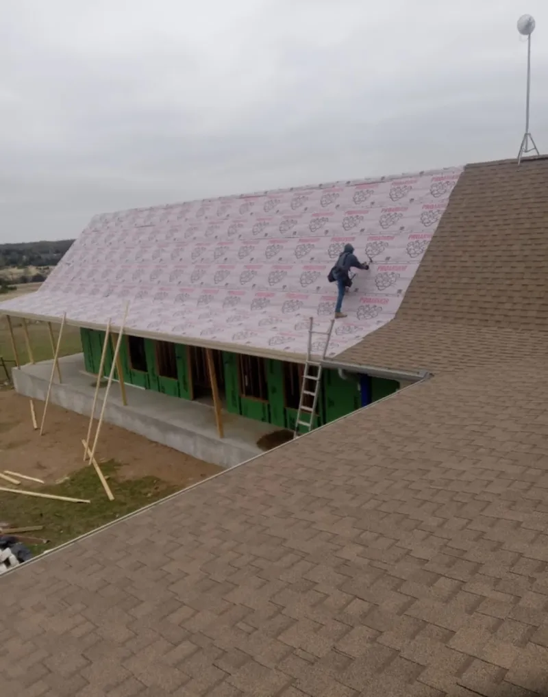 Worker preparing underlayment for a metal roof installation in Pacific Grove